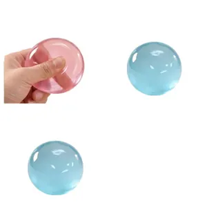 Detail view of translucent pink and blue coconut ball squishy toys being squeezed for stress relief
