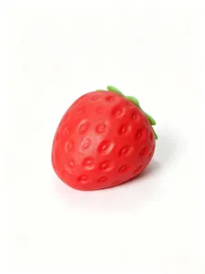 Primer plano del juguete realista de fresa roja squishy mostrando su textura suave y lenta