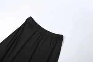 Close-up detail shot of black elastic waistband on high-waist skirt with soft drape fabric