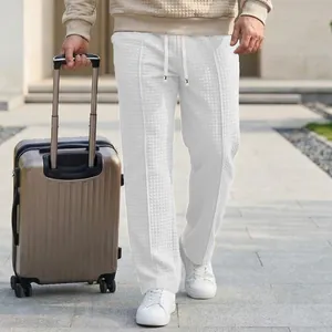 Detail shot of men's white waffle knit pants featuring an elastic drawstring waist