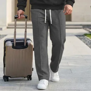 Detail view of men's dark grey waffle-textured casual pants with elastic drawstring waist.
