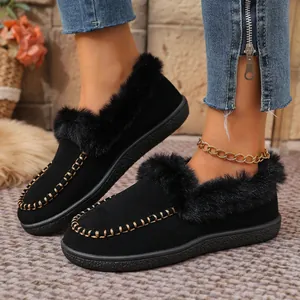 Close-up view of elegant black suede loafers featuring cozy faux fur trim and gold chain details