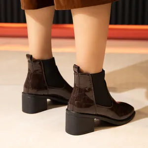 Detalle posterior de botines marrones de mujer con grabado de cocodrilo y tacón