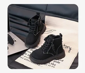 Close-up of black children's Martin boots featuring white stitching and a side zipper detail