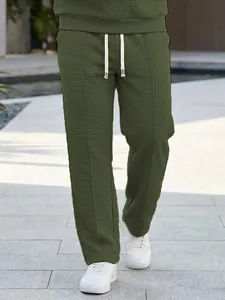 Detailed view of men's olive green waffle knit casual pants with an elastic waist design.