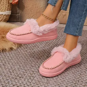 Detail view of pink suede loafers featuring plush fur trim and elegant golden stitching