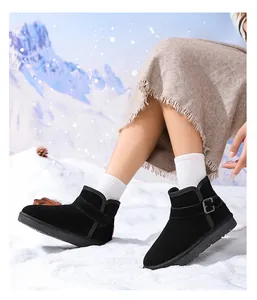 Detail of children's black leather snow boots with buckle strap in snowy setting