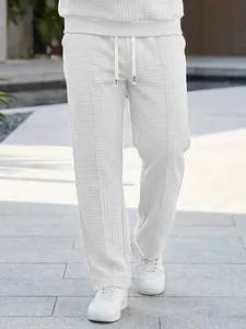 Close-up detail of white waffle-knit men's trousers featuring a comfortable drawstring waist