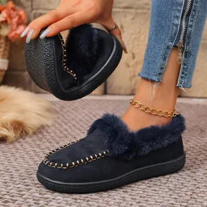 Close-up showing the flexible sole of navy blue suede loafers with warm faux fur