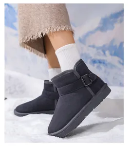 Close-up detail of grey children's warm leather snow boots with a stylish buckle strap in snow