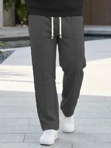 Detailed macro view of men's dark grey waffle texture pants with white drawstring