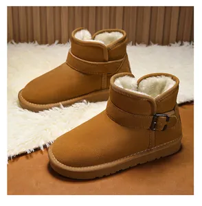 Close-up detail of children's tan suede snow boots featuring thick white faux fur lining