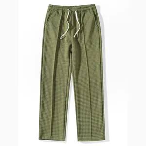 Detailed view of olive green waffle knit men's pants with a drawstring elastic waist.