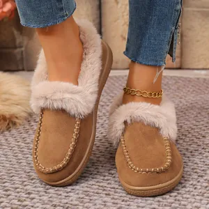 Close-up of brown suede winter slippers with faux fur lining and hand-stitched detail