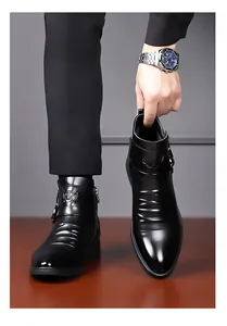 Detailansicht schwarzer Business-Chelsea-Boots aus Leder mit Schnalle und Wappenlogo.