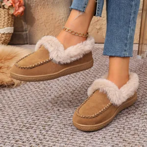 Close-up of warm brown suede winter flats with cozy faux fur trim and stitching