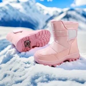 Pinkfarbene Mädchen-Schneestiefel mit glänzenden Sternen vor schneebedeckten Bergen.