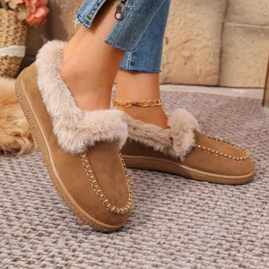 Close-up detail of cozy brown suede loafers with thick faux fur lining for winter.