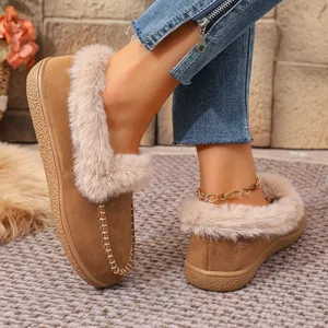Close-up of warm suede winter shoes with plush faux fur trim and textured soles.