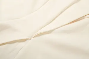 Nahaufnahme des cremefarbenen Stoffes und der präzisen Nähte des eleganten Damen-Sets
