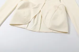 Detailansicht eines eleganten cremefarbenen Langarmshirts mit festem Wickelsaum-Design
