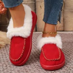 Detail of red suede winter slippers with cozy white faux fur trim and gold stitching