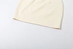 Detaillierte Makroansicht des cremefarbenen Strickrocksaums mit hochwertiger Doppelnaht.