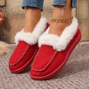 Detail view of red suede winter loafers with plush white faux fur trim and gold stitching.