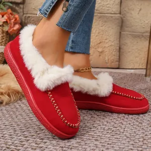 Close-up of red suede winter slippers with plush white fur trim and gold stitching detail.