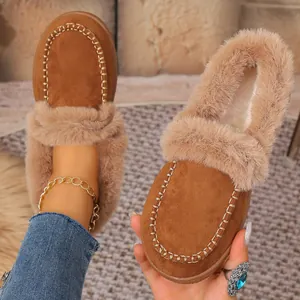 Close-up of brown suede winter loafers with plush faux fur trim and hand-stitched detailing.