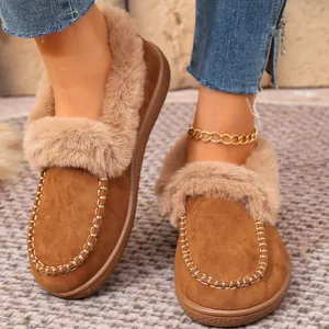 Close-up view of brown suede slippers with fluffy fur lining and decorative stitching