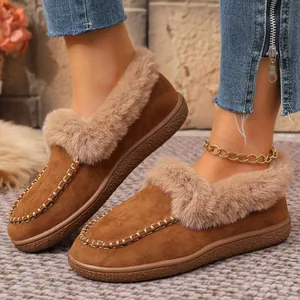 Detailed view of women's warm winter loafers featuring faux fur trim and brown suede