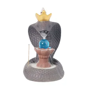 Creative ceramic cobra backflow incense burner with golden crown and blue glass sphere ornament
