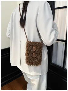 Fashionable brown plush fuzzy crossbody bag featuring a retro horn toggle closure