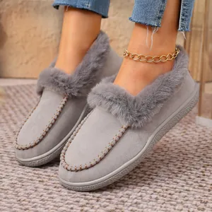 Close-up of grey suede slippers with faux fur trim and decorative stitching details