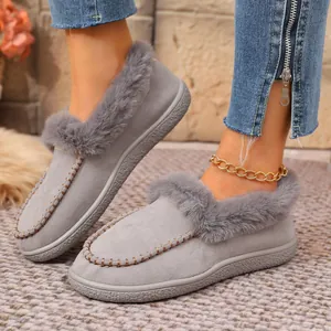 Close-up of grey suede winter slippers with plush faux fur lining and soft warm trim