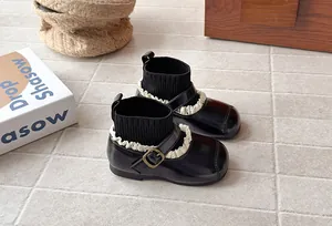 Detailed view of girls' retro leather sock boots with lace trim and buckle detail
