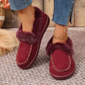 Detail of burgundy suede flat shoes with faux fur lining and gold stitching