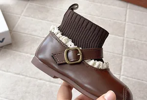Detail shot of vintage brown children's sock boots with lace trim and buckle