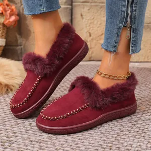 Close-up of burgundy suede winter slippers with plush faux fur lining and trim