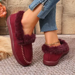 Warm wine red suede flat loafers featuring plush faux fur lining and decorative stitching.