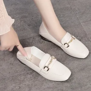 Close-up of soft beige leather loafers showing flexible heel and metal buckle