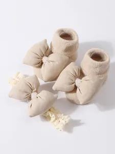 Detalle de primer plano de calcetines y diadema beige para bebé con lazos de tela