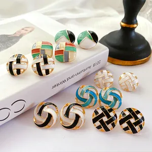 Close-up of vintage round cutout enamel stud earrings in various colorful designs