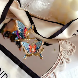 Detailed view of a vintage butterfly brooch featuring colorful enamel and pearl embellishments
