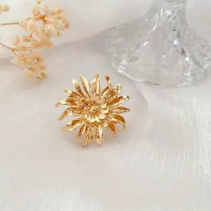 Goldene Chrysanthemen-Brosche im barocken Vintage-Stil auf elegantem weißem Seidenstoff