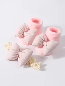 Set de calcetines para bebé rosas y diadema de encaje con grandes lazos decorativos.
