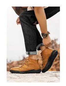Botas de exterior para hombre en color marrón cosidas a mano usadas por un modelo.