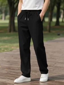 Detail of men's casual black corduroy pants with drawstring waist in outdoor setting