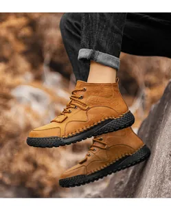 Primer plano de botas de montaña marrones para hombre cosidas a mano sobre roca